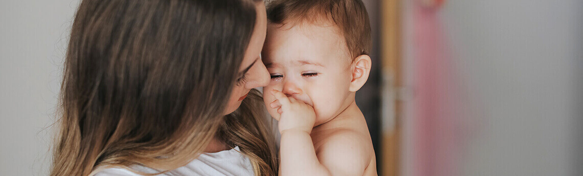 Bebê chorando no colo da mãe