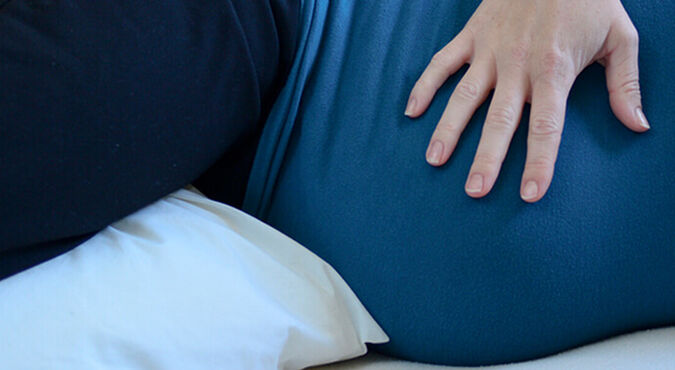 Barriga de grávida deitada de lado