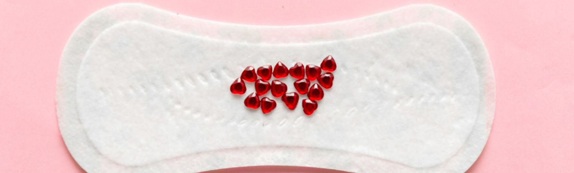 absorvente feminino com gotículas vermelhas imitando sangue de nidação
