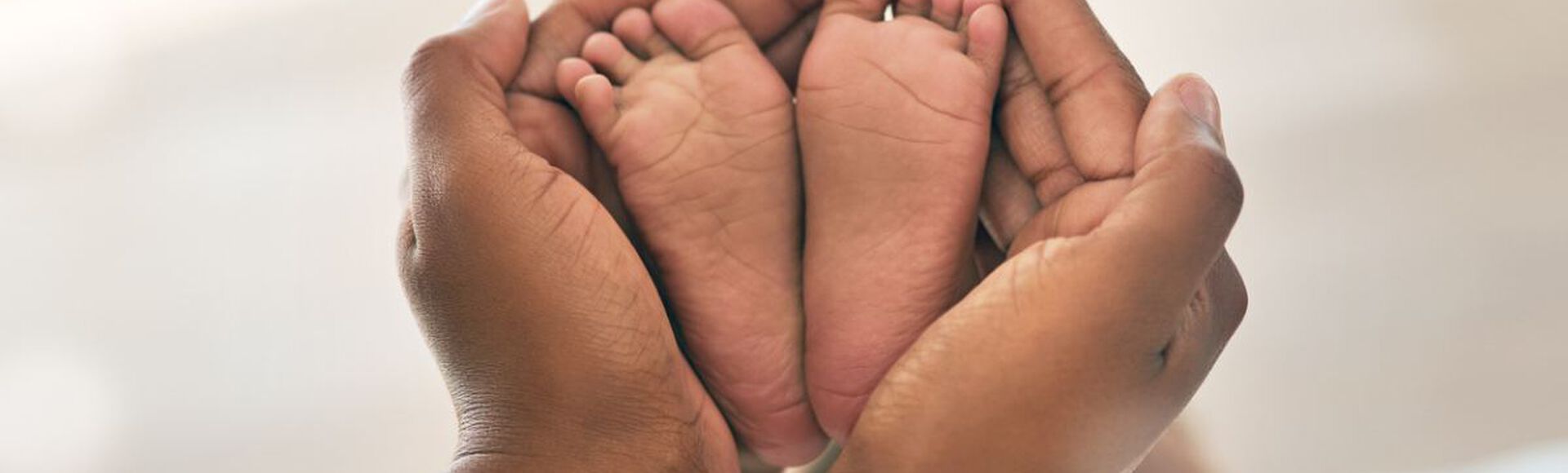 pés de bebe envoltos por mãos de adulto