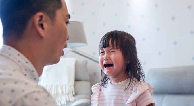 Criança chorando em frente ao pai