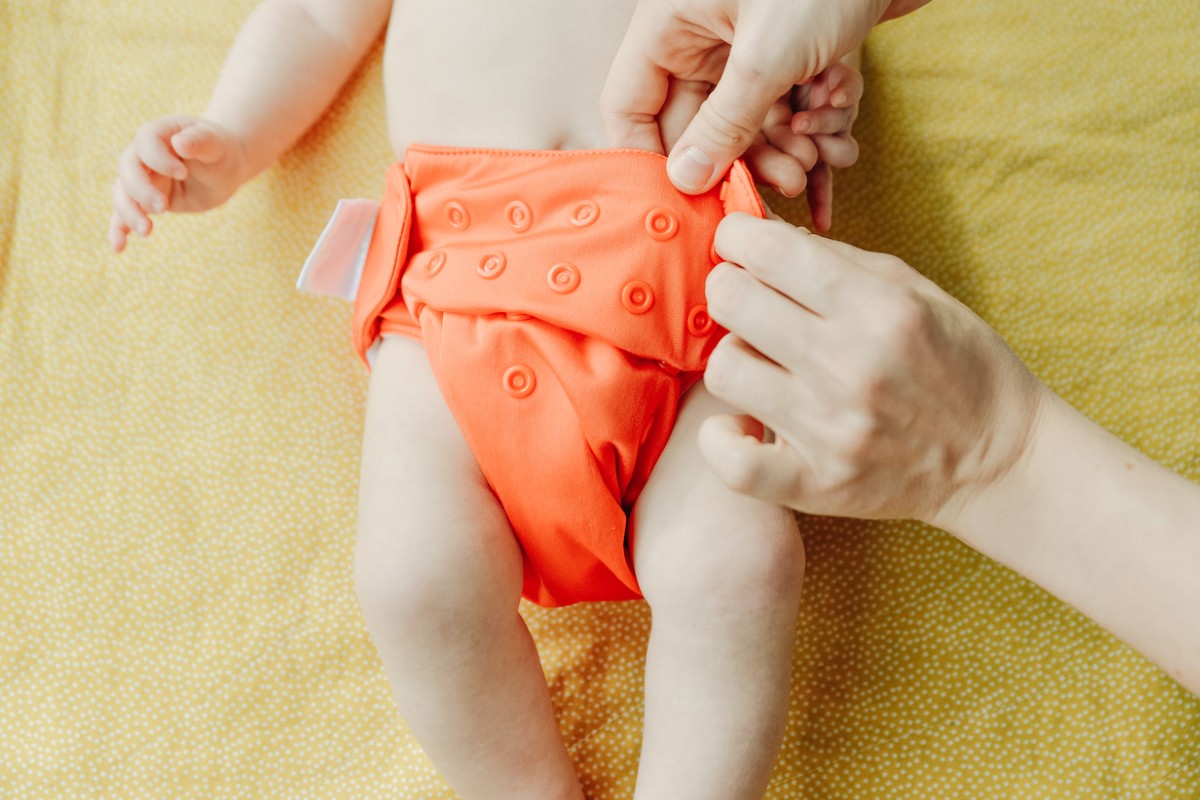 Bebê vestindo fralda reutilizável laranja